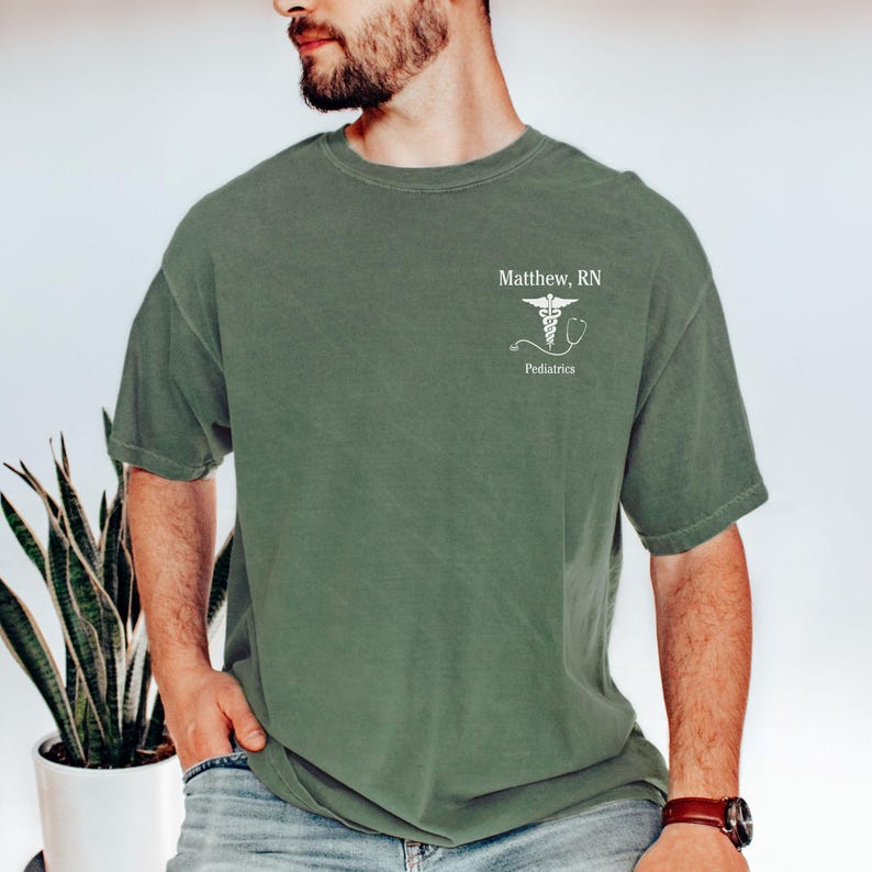 Puede incluir: Una camiseta verde con un s&iacute;mbolo m&eacute;dico blanco y el texto "Matthew, RN Pediatr&iacute;a".