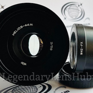 May include: A black camera lens with the text "HELIOS-44M 2/58" printed on the side. The lens is designed for a 35mm camera.