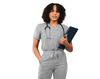 May include: A woman wearing a grey scrub top and matching scrub pants with a stethoscope around her neck. She is holding a blue folder and looking at the camera.