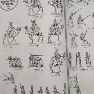 May include: A black and white illustration of a set of toy soldiers from the C.B.G. Expedition d'Egypte collection. The soldiers are depicted in various poses, including standing, kneeling, and riding camels. The illustration includes the text "R&eacute;giment des Dromadaires" and the numbers 4019/b, 4019/a, 4021/a, 4020/b, 4020/a, 4025/b, 4025/a, 4026/b, 4027/b, 4029/b, 4029/a, 4022/b, 4022/a, 4021/b, 4024/b, 4024/c, 4024/a, 4023/c, 4023/b, 4023/a, 4033/b, 4032/b, 4032/a, 4031/b.
