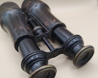 Könnte beinhalten: Vintage-Fernglas in Schwarz mit Messingakzenten. Das Fernglas hat einen abgenutzten, antiken Look und ist scharf.
