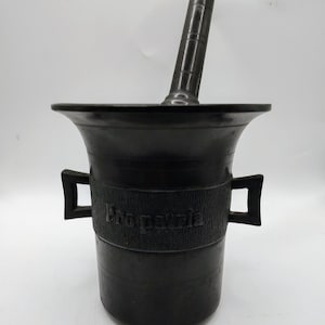 May include: Black mortar and pestle with the word "Pro patria" inscribed on the side.