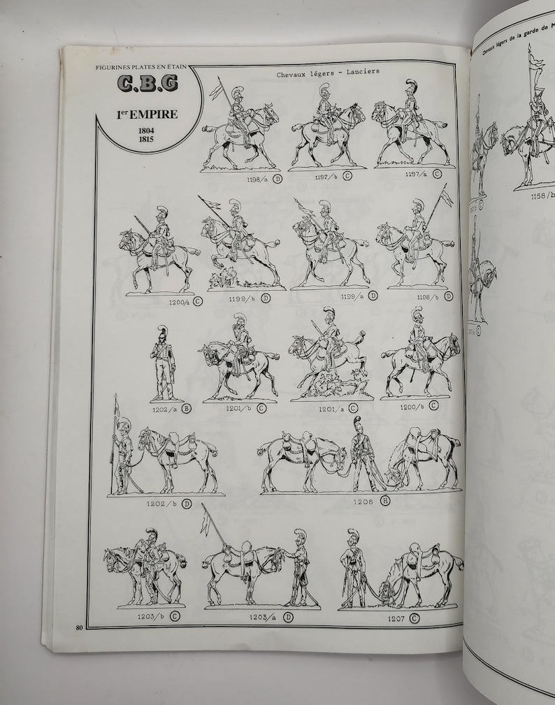 May include: A black and white illustration of a set of toy soldiers on horseback. The soldiers are wearing helmets and carrying swords. The image includes the text "C.B.G 1st Empire 1804 1815".