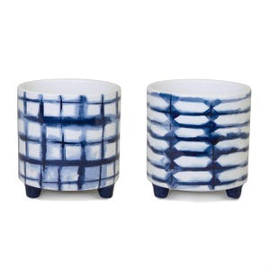 May include: Two ceramic planters with a white base and blue watercolor designs. One planter has a grid pattern, the other has a horizontal stripe pattern. Each planter has three small, dark blue feet.