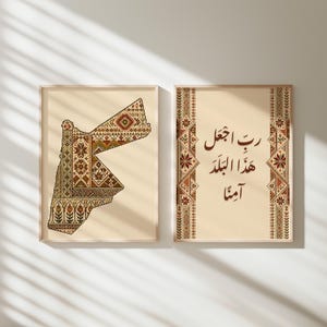 May include: Two framed wall art prints with a cream background. The left print features a map of Jordan filled with intricate, multi-colored geometric and floral patterns. The right print displays Arabic calligraphy framed by vertical decorative borders.
