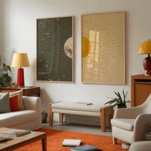 Living room interior showing two large framed celestial posters hanging on a white wall above a beige bench, flanked by a couch and a chair on an orange rug.