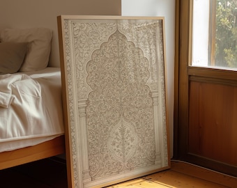 May include: A framed artwork with a detailed floral pattern in beige and cream hues. The design features an archway motif with symmetrical floral elements. The artwork is leaning against a wall. The frame is a light wood colour.
