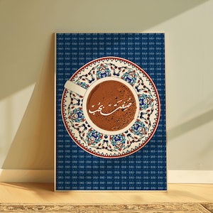 May include: A rectangular wall art print featuring a top-down view of a coffee cup centered on a saucer with a white, red, and blue floral pattern. The coffee surface displays white Arabic calligraphy. The background is a dark blue textured grid.