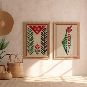 May include: Two framed cross-stitch artworks with Palestinian designs. One displays a geometric pattern in red, black, and green. The other shows a map outline with similar colours. A woven hat and plants in baskets are also visible in the image.