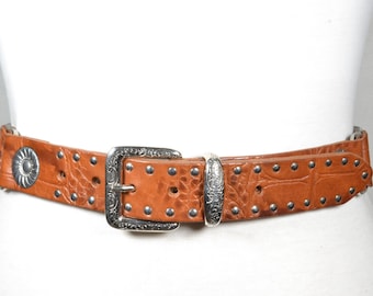 Cinturón vintage de cuero marrón repujado con hebilla western ornamentada y detalles florales con tachuelas, estilo vaquera