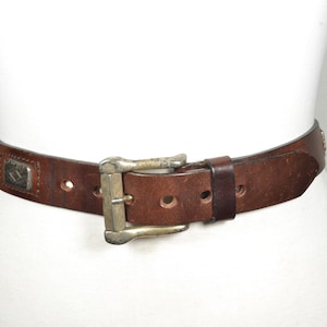 Vintage brunt slitet läderbälte med concho-detaljer och metallspänne, rustikt western unisex