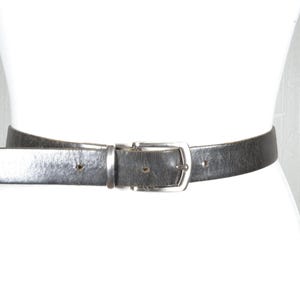 Cinturón de piel negro vintage con hebilla plateada, accesorio clásico y atemporal para mujer