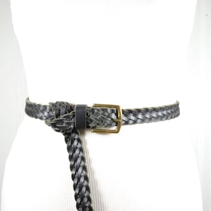 May include: A black braided leather belt with a brass buckle.