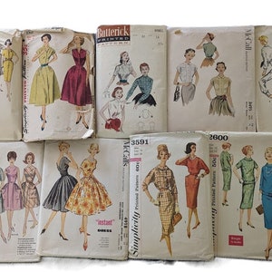 May include: A collection of vintage sewing patterns for dresses. The patterns are from Simplicity, Butterick, and McCall's. The patterns feature different styles of dresses, including a-line, fit and flare, and sheath dresses. The patterns are in various colors, including red, blue, green, and yellow.