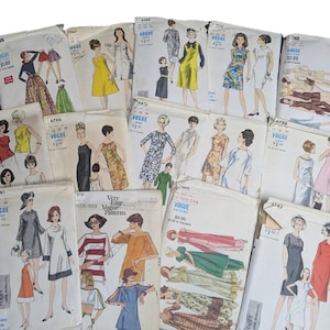 May include: A selection of vintage Vogue sewing patterns, displaying illustrations of dresses and other clothing items. The patterns depict diverse styles from the mid-20th century, with prices and pattern numbers visible on the covers.