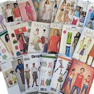 May include: A collection of vintage sewing patterns from brands like McCall's and Simplicity. The patterns feature illustrations of clothing designs, including dresses, tops, and pants. The covers display various colors and styles.