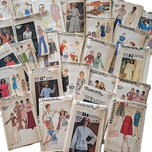 Op de afbeelding: Een verzameling vintage naaipatronen met verschillende ontwerpen voor dameskleding. De patronen zijn van het merk Butterick en omvatten een verscheidenheid aan stijlen, zoals jurken, rokken, blouses en broeken. De patronen zijn in verschillende kleuren, waaronder wit, roze, blauw en groen.