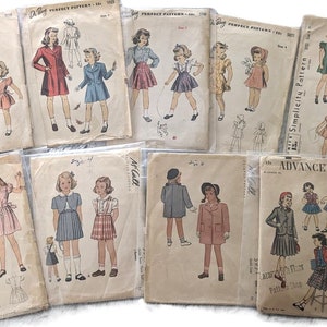 Peut inclure: Une collection de patrons de couture vintage pour vêtements de filles. Les patrons présentent des illustrations de robes, manteaux et jupes pour enfants. Les patrons sont dans leur emballage d'origine, avec différentes marques et tailles visibles.