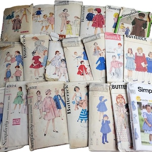 May include: A collection of vintage sewing patterns for children's clothing. The patterns are from brands like Butterick and Simplicity, featuring illustrations of dresses, coats, and other garments. The covers display colorful designs and text.