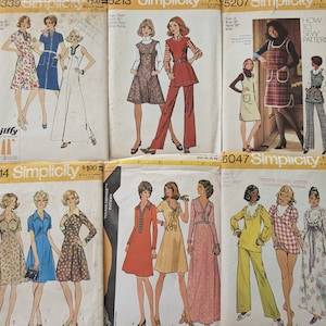 Peut inclure: Plusieurs enveloppes de patrons de couture Simplicity vintage. Les patrons présentent des illustrations de femmes dans diverses modes des années 1970, notamment des robes, des combinaisons et des tailleurs-pantalons. Les enveloppes sont jaunies et affichent le logo Simplicity.