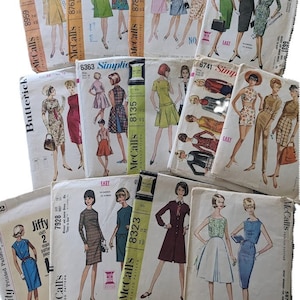 May include: A stack of vintage sewing patterns for dresses, featuring various styles and sizes. The patterns are from McCall's and Simplicity brands, with numbers like 8959, 8761, 8785, 8135, 6363, 6741, 7928, 8323, and 5874. The patterns are printed on paper and have illustrations of the dresses.