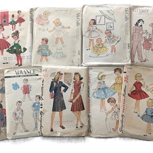 May include: A collection of vintage sewing patterns for children's clothing. The patterns feature illustrations of dresses, suits, and pajamas. Brands include McCall's, Butterick, Advance, and Simplicity. The patterns are from the mid-20th century.