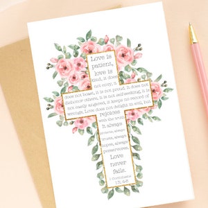 May include: A white card with a gold cross decorated with pink flowers. The card features a bible verse about love from 1 Corinthians 13:4-8. The text reads: "Love is patient, love is kind, it does not envy, does not boast, it is not proud. It does not dishonor others, it is not self-seeking, it is not easily angered, it keeps no record of wrongs. Love does not delight in evil, but rejoices with the truth. It always protects, always trusts, always hopes, always perseveres. Love never fails. 1 Corinthians 13:4-8"