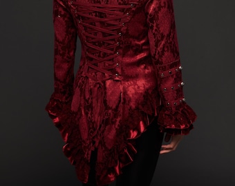 May include: A red brocade jacket with a lace-up back and ruffled trim. The jacket has a fitted silhouette and long sleeves with decorative buttons.