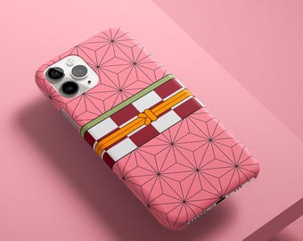 May include: Pink phone case with a geometric pattern and a decorative band featuring red, white, and yellow stripes. The case has a camera cutout and is designed to fit a smartphone.