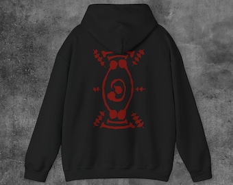 Puede incluir: Sudadera con capucha negra con un diseño tribal rojo en la espalda. El diseño es un patrón simétrico con una espiral central y varias formas y líneas. La sudadera tiene capucha y mangas largas, perfecta para uso casual.