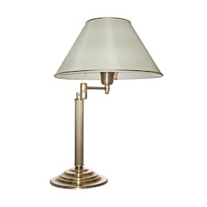 Könnte beinhalten: Eine Schreibtischlampe aus Messing mit cremefarbenem Lampenschirm. Die Lampe hat einen runden Sockel, eine geriffelte Säule und einen verstellbaren Arm. Der Lampenschirm ist konisch mit goldenem Rand. Die Lampe ist für einen Schreibtisch oder Tisch konzipiert. Höhe ca. 30 cm.