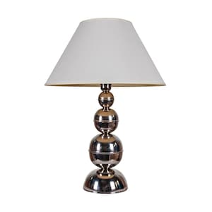 Può includere: Una lampada da tavolo moderna con paralume bianco e base cromata lucida. La base è composta da sfere impilate, che aggiungono un tocco contemporaneo unico al design. La lampada è progettata per uso interno.