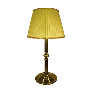 Può includere: Una lampada da tavolo in ottone con paralume giallo plissettato. La lampada ha una base rotonda e uno stelo decorativo. Il paralume è rifinito con un bordo dorato. La lampada è un design classico.