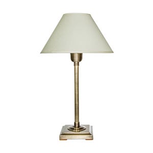 May include: A small table lamp with a cream-colored lampshade and a brass-colored base. The lampshade is conical, and the base is square. The lamp is designed for indoor use and provides soft, ambient lighting.