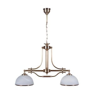 May include: A bronze-finished ceiling light with two frosted glass shades. The light has a decorative design and is suspended by a chain. The dome-shaped shades are white and light brown. The light fixture is designed in a vintage style.