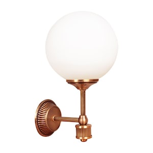 May include: A wall-mounted light fixture with a spherical white glass shade. The fixture has a bronze finish with a decorative circular base and a straight arm. The light is designed for indoor use.