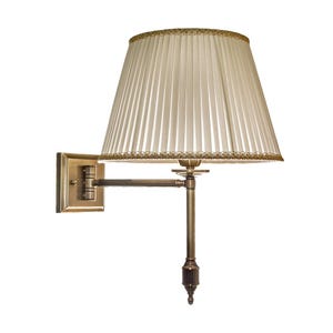 Op de afbeelding: Een wandlamp met een geplooide crèmekleurige lampenkap, afgewerkt met goud. De lamp heeft een messingkleurige verstelbare arm en een vierkante wandbevestiging. Het ontwerp is klassiek en elegant.