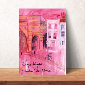 K&ouml;nnte beinhalten: Ein Aquarellbild einer rosafarbenen Stadtlandschaft mit einem Fahrrad im Vordergrund. Der Text "Carys Wright London Sketchbook" befindet sich am unteren Rand des Bildes.