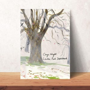 Könnte beinhalten: Ein Skizzenbuch mit einer Aquarellillustration eines Baumes. Auf dem Einband steht in handschriftlicher Schrift der Text "Carys Wright London Park Sketchbook". Das Kunstwerk verwendet Grautöne, Braun und Grün.