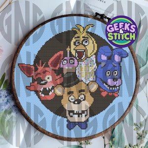 May include: Cross-stitch pattern featuring five characters from the Five Nights at Freddy's video game series. The characters are Freddy Fazbear, Chica the Chicken, Foxy the Pirate Fox, Bonnie the Bunny, and Golden Freddy. The pattern is on a blue background with a brown wooden frame. The text "Geeks & Stitch" is in a white circle with a black outline.