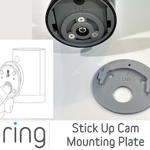 May include: A gray plastic mounting plate for a Ring Stick Up Cam. The plate has a circular shape with a raised lip and a small hole in the center. The words "Stick Up Cam Mounting Plate" are printed below the plate.