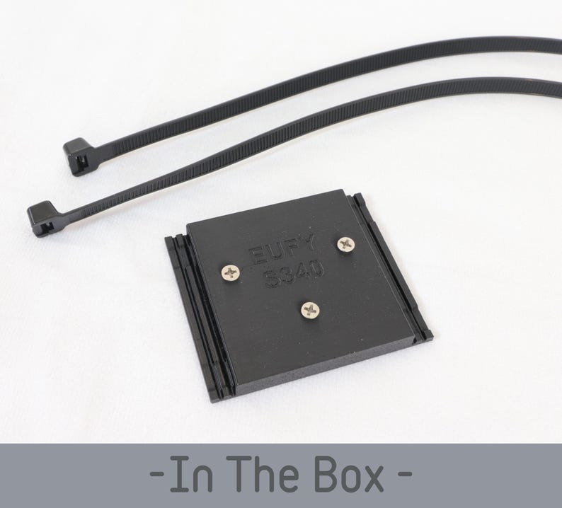 May include: A black rectangular device with the text "Eufy S340" and three screws, accompanied by two black cable ties. The items are on a white surface. The phrase "- In The Box -" is at the bottom.