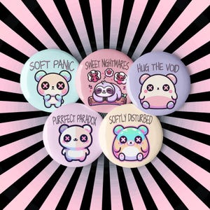 May include: Five pastel-colored round buttons with cute cartoon animals and text. The buttons read "Soft Panic", "Sweet Nightmares", "Hug the Void", "Purrfect Paradox", and "Softly Disturbed".