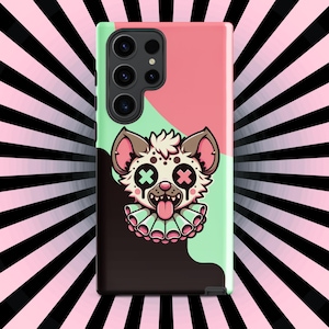 May include: A phone case with a black and pink background featuring a cartoon hyena with green eyes and a pink tongue sticking out. The hyena is wearing a pink and green collar with a ruffle.