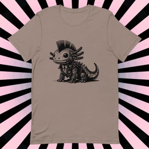 K&ouml;nnte beinhalten: Ein hellbraunes T-Shirt mit einer Schwarzwei&szlig;illustration eines Punk-Axolotls, das eine Lederjacke und einen Irokesenschnitt tr&auml;gt.