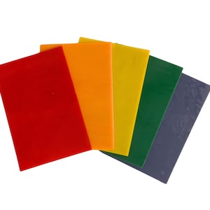 May include: A fan of six rectangular, solid-colored sheets. The colors are red, orange, yellow, green, and blue-gray. The sheets are arranged in a fanned-out pattern, with the red sheet in the front.