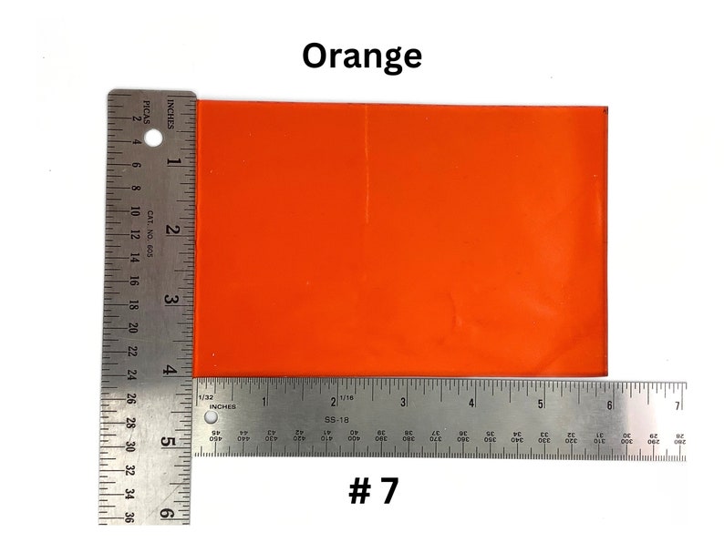 May include: A bright orange square of material, measuring approximately 6 inches by 4 inches, with a ruler on either side. The material is labeled "#7".