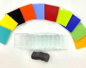 May include: A collection of square acrylic tiles in various colors including turquoise, yellow, black, orange, light blue, red, lime green, dark blue, light green, and yellow-orange, alongside clear rectangular tiles and round dark gray magnets.