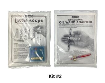 May include: Two sealed plastic packages labeled "Little Scope" and "Little Scope Oil Wand Adaptor." The "Little Scope" package shows diagrams of the scope and the text "A miniature little scope with a big image." The text "Kit #2" is at the bottom.