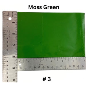 May include: A close-up of a moss green vinyl sheet, measured with a ruler. The sheet is 6 inches wide and 6 inches long. #3